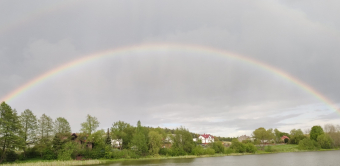 Tęcza nad jeziorem i wioską