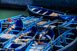 Blue boats anchored , framing fishermen